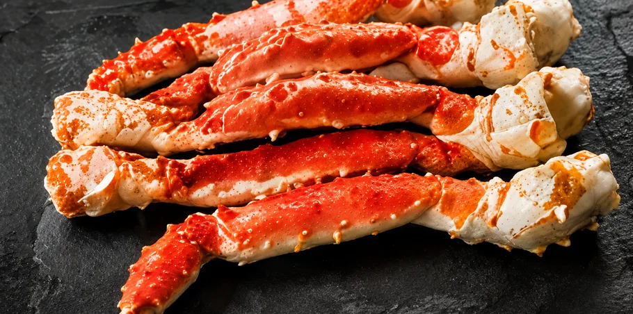 Premium Norwegian king crab legs served on a dark slate surface, showcasing their rich red color and tender meat.