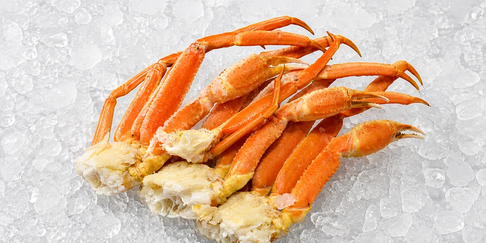 Fresh Snow Crab legs and claws arranged on crushed ice, showcasing their bright orange shell, delicate texture, and premium seafood presentation. Ideal for wholesale seafood suppliers, restaurants, hotels, retailers, and foodservice businesses.